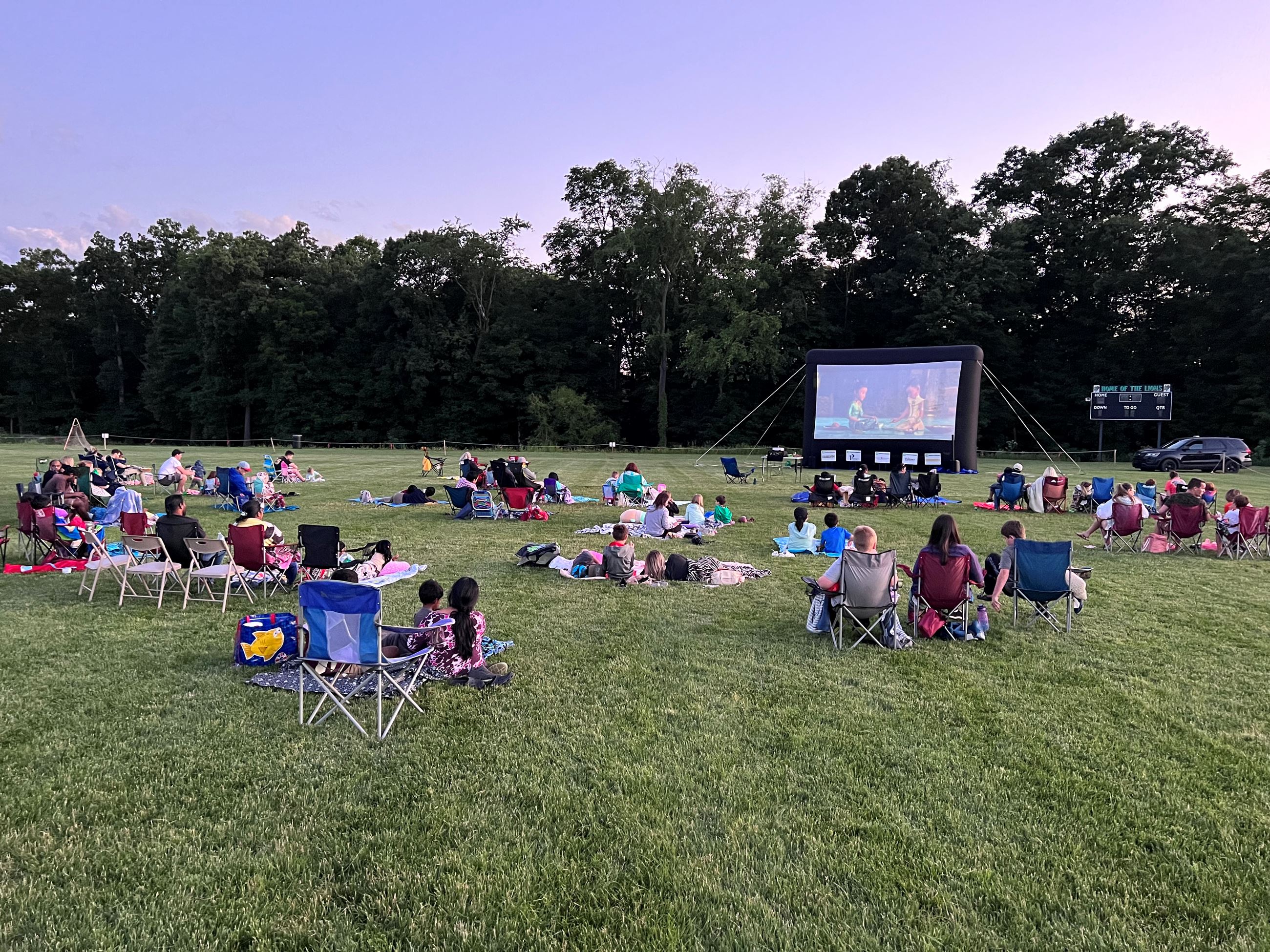 people watching movie screen in park1