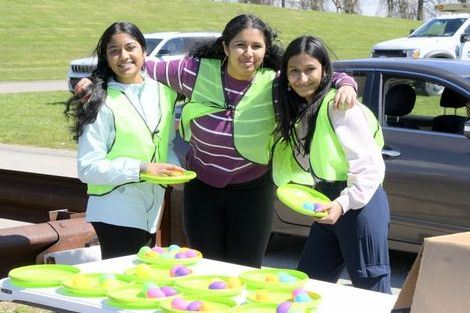 3 volunteers posing with plastic eggs