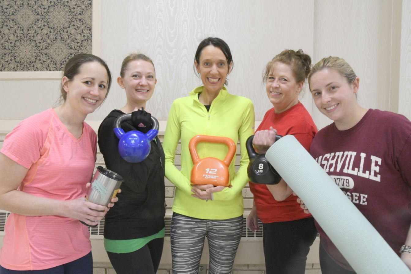 five women posing with kettlebells