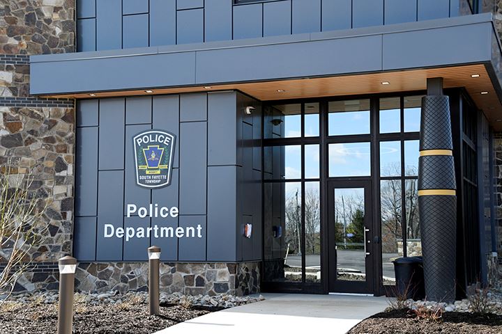Police entrance closeup outside with Police Department lettering and patch on gray wall