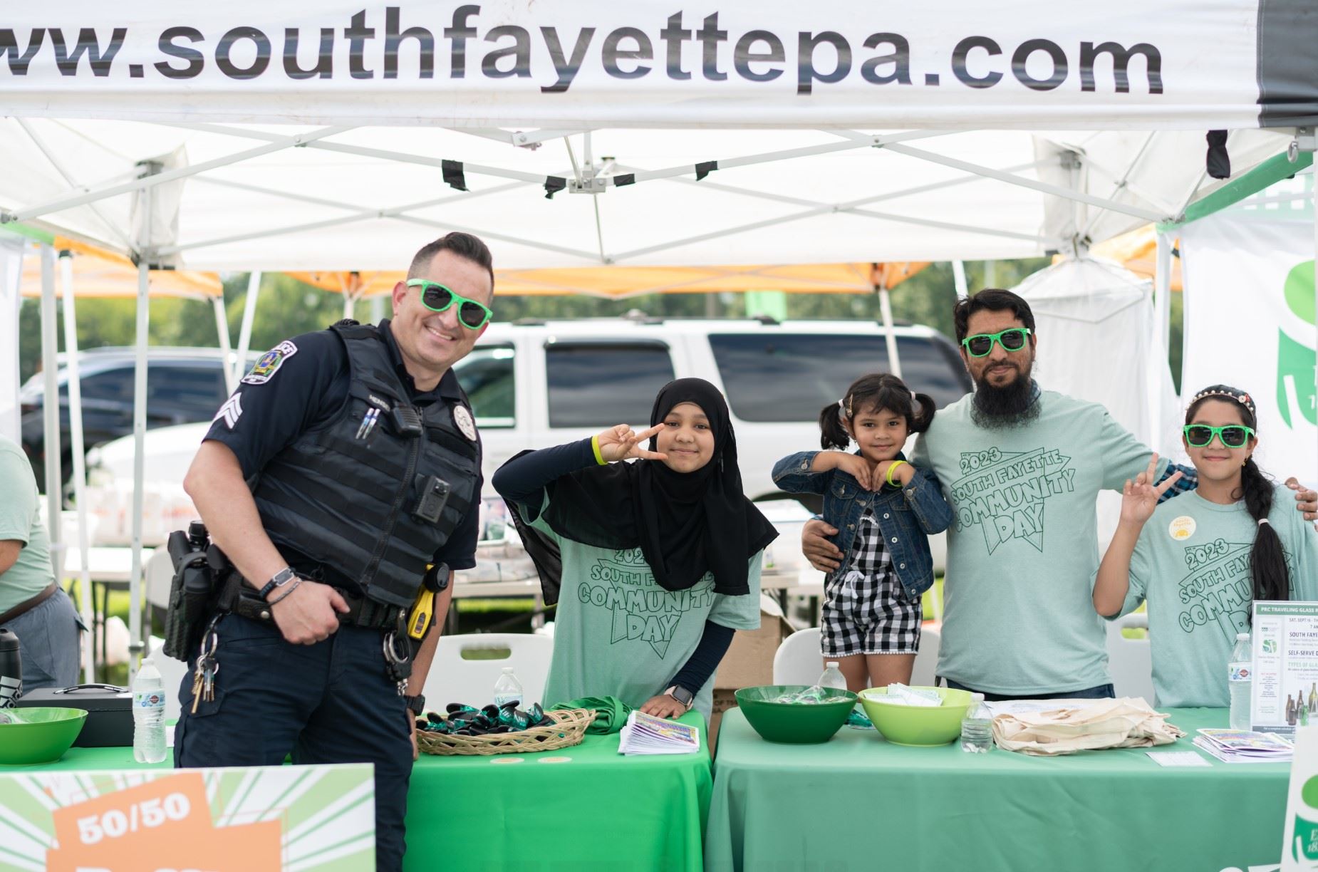 Community Day volunteers at booth with police officer