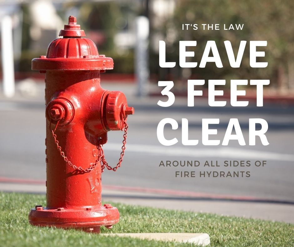 Red fire hydrant in grass with message to leave 3 feet of space fire hydrants